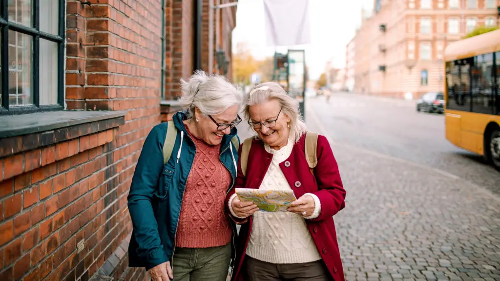 Two older women reading a map while exploring a city, illustrating travel support for people with kidney disease